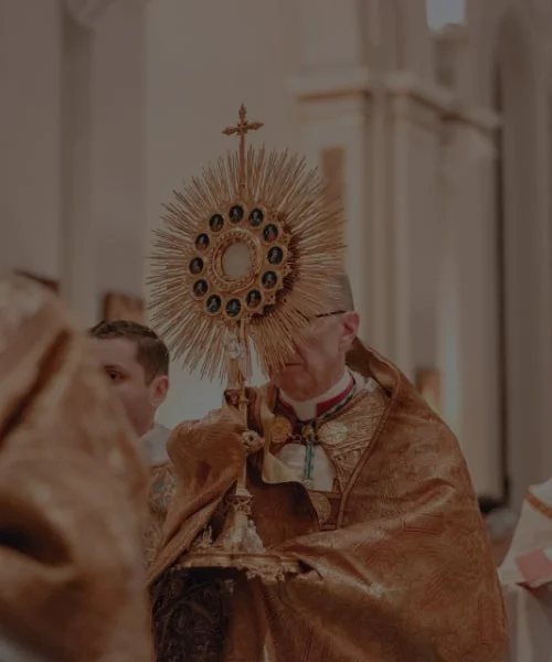 Widok na kapłana niosącego monstrancję